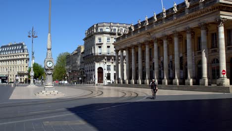 Grand-Theater-Opera-House-square-angle-view-with-delivery-biker-passing-during-the-COVID-19-pandemic,-Dolly-right-reveal-shot