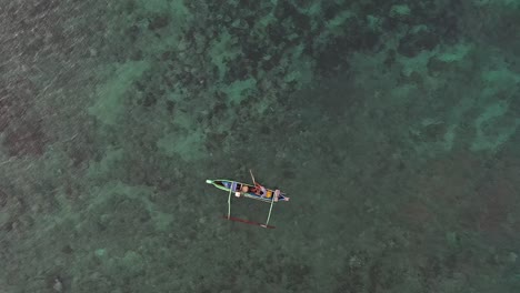 Luftaufnahme-Eines-Fischers,-Der-Auf-Einem-Boot-Am-Rosafarbenen-Strand-In-Indonesien-Lombok-Fährt-–-Luftaufnahme