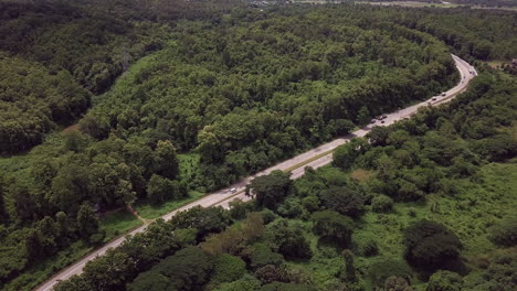 Logistic-concept-aerial-view-of-countryside-road---motorway-passing-through-the-serene-lush-greenery-and-foliage-tropical-rain-forest-mountain-landscape