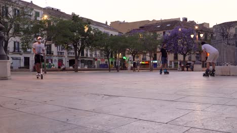 People-in-face-mask-on-roller-skates-and-scooter-on-Merced-square