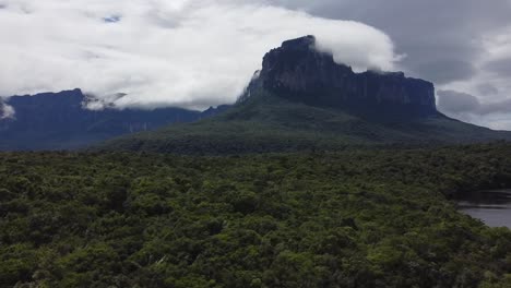 Aerial-view-of-the-Auyantepuy-mesa,-a-river,-and-the-Amazon-rainforest,-Canaima-National-park,-Venezuela,-panorama-curve