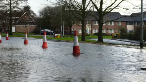 Storm-Christoph-car-driving-slow-rainy-flooding-village-road-splashing-street-cones