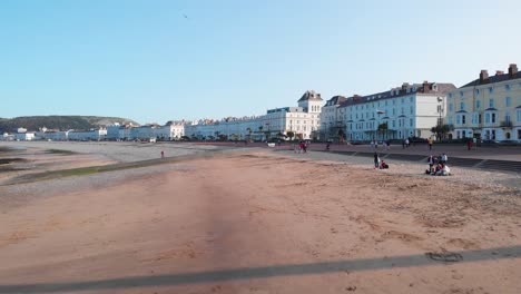 Gente-Relajándose-En-La-Playa-A-última-Hora-De-La-Tarde,-Llandudno,-Gales