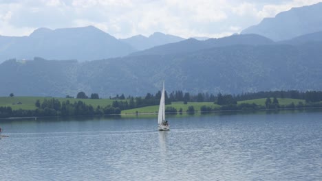 Sailing-Boat-on-Lake-Forggensee-near-Fuessen-in-Bavaria,-Germany