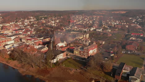 Small-town-with-church-on-fire,-Wide-Aerial,-Slow-Motion