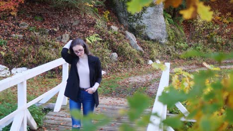 Casual-Teenage-Girl-Walking-Over-Bridge-in-Public-Park-on-Autumn-Day-Slow-Motion