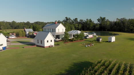 Aerial-flight-over-corn-field-revealing-farmhouse-wedding-set-up-in-countryside