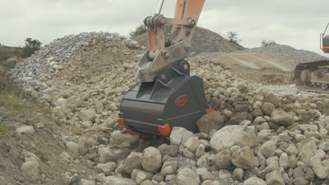 Using-new-steel-bucket-on-digger-picking-up-stone-filling-conveyor