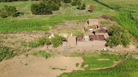 Umlaufende-Antenne-Eines-Bescheidenen-Ländlichen-Afrikanischen-Bauernhauses-Mit-Familie-Im-Hof