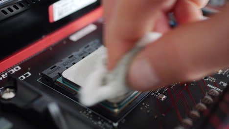 Un-Técnico-De-Reparación-De-Computadoras-Instalando-Una-CPU-Amd-Ryzen-2400g-En-Una-Placa-Base-Y-Limpiándola-Con-Alcohol-Antes-De-Aplicar-Pasta-Térmica