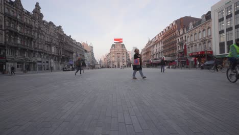 People-walk-on-the-Place-de-BrouckÃ¨re-wearing-face-masks-to-protect-from-coronavirus-during-lockdown