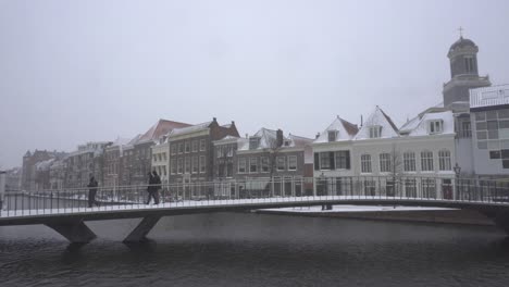 Catharinabrug-Leiden-bridge-winter-snow,-people-walking-over-Rhine-Netherlands