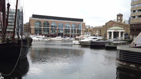 Old-sailing-boats-moored-camera-pans-right-to-luxury-house-boat