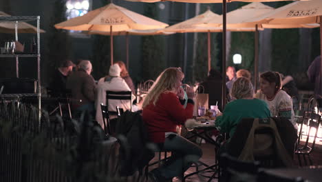 Tiro-De-Cardán-De-Personas-Cenando-Al-Aire-Libre-Cerca-Del-Fuego-En-La-Noche-Fría