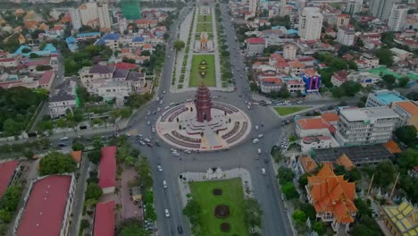 Independence-Monument-At-The-Intersection-Of-Norodom-Boulevard-And-Sihanouk-Boulevard-In-Phnom-Penh---Sunset-View---aerial,-slow-motion