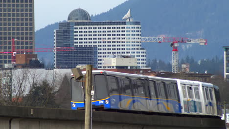 Expo-Line-Skytrain-Dreht-Auf-Gebogener-Strecke-Mit-Turmdrehkranen-Und-Gebäuden-Im-Hintergrund-In-Vancouver,-Britisch-Kolumbien,-Kanada