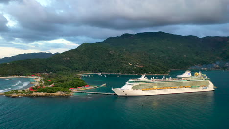 Amplia-Toma-De-Drones-De-Un-Crucero-Atracado-En-Haití-Con-Montañas-Costeras-En-El-Fondo