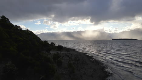 Stunning-sun-rays-peeking-from-behind-the-clouds-above-Lake-Te-Anau-in-New-Zealand