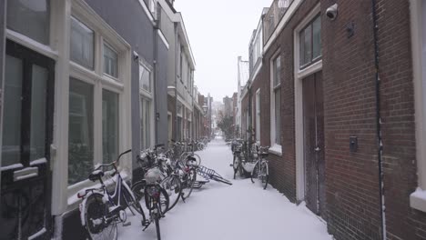 Point-of-view-shot-walking-through-Dutch-city-street-in-winter-snow,-Netherlands