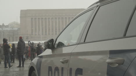 Close-up-of-left-side-of-police-car-parked-near-protest-in-front-of-Helsinki-Parliament