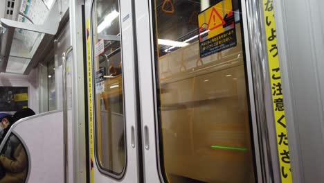 POV-from-inside-train-subway-commuter-to-the-train-door-while-moving-in-Tokyo,Japan