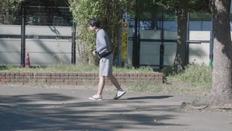 Erwachsener-Japanischer-Läufer,-Der-Sich-An-Einem-Sonnigen-Tag-Im-Park-In-Tokio,-Japan,-Ausdehnt