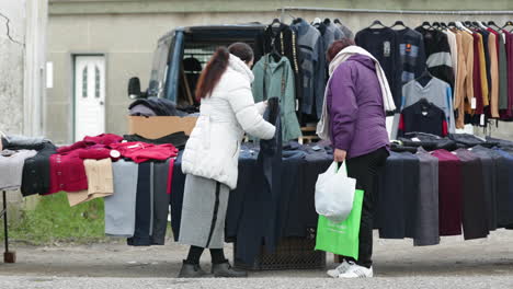 Friendly-Female-Clothing-Stall-Holder-Selling-To-Customer-During-Winter-In-Leiria,-Portugal