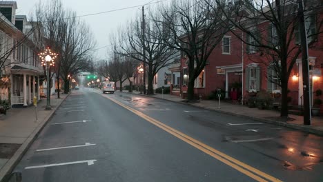 US-Mail-delivery-truck-drives-through-quiet-colonial-American-town-during-Christmas-season