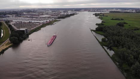 Luftaufnahme-über-Dem-Fluss-Mit-Langsamem-Podest-Hinunter-Zum-Trivor-Binnentanker,-Der-Den-Fluss-Befährt