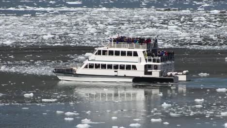 Small-engine-boat-sailing-in-the-frozen-waters-of-Tarr-Inlet-in-Alaska,-Glacier-Bay