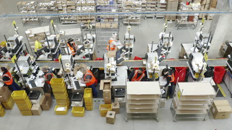 Aerial-Shot-Of-Employees-Sorting-Mail,-Packages-On-A-Conveyer-Belt-In-A-Distribution-Facility
