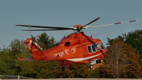 Un-Helicóptero-De-Emergencia-Naranja-Despegando,-Mississauga,-Canadá,-Plano-General
