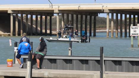 Three-men-on-the-dock-on-Packery-Channel-with-three-men-on-fishing-boat-in-the-channel