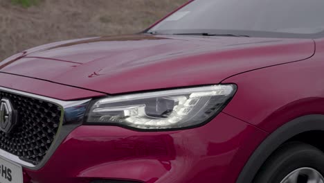 red-SUV-grill-and-headlight-on-the-road