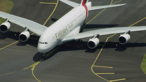 reveal-of-a-A380-plane-on-the-taxiway-turning-to-the-apron-with-zoom-out