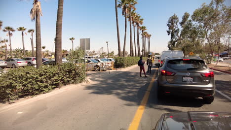 Street-Vendors-Approaching-Cars-Heading-To-Cross-The-Border-In-Tijuana,-Mexico