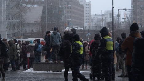 Wide-shot-of-the-crowds-of-people-gathered-for-the-covid-19-protests-in-Helsinki,-cold-and-snowing