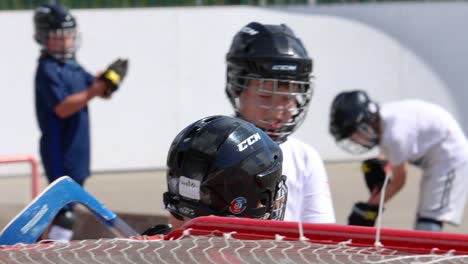 Niño-Terminó-La-Práctica-De-La-Pelota-De-Hockey,-Caminando-Por-Amigos-Y-Entrenadores,-Cámara-Lenta