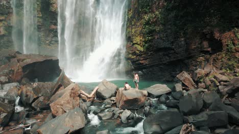 People-on-rocks-at-Nauyaca-Waterfalls,-Costa-Rica