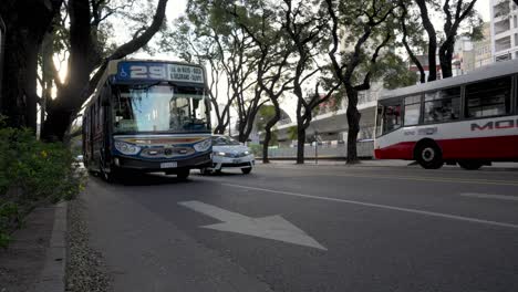 Low-Angle-Aufnahme-Des-Verkehrs-Auf-Der-Straße-In-Buenos-Aires,-Autos-Und-Busse,-Die-Auf-Der-Straße-In-Argentinien-Fahren