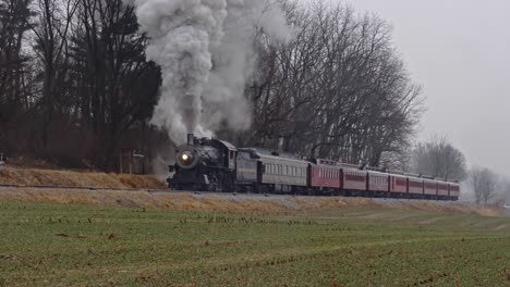 Eine-Dampfmaschine-Und-Personenwagen,-Die-In-Einem-Leichten-Regensturm-Die-Steigung-Hinauffahren