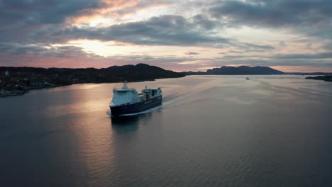 Cargoship-Samskip-Kvitbjorn-southbound-in-Norwegian-coastal-waters-during-sunset---Aerial-from-port-bow-in-front-of-ship