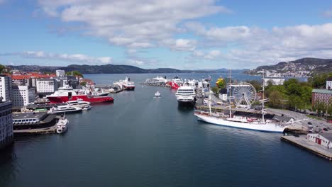 Sommersonniger-Tag-Im-Hafen-Von-Bergen---Nebenan-Vertäute-Schiffe-Und-Expressboot,-Das-In-Der-Mitte-Abfährt---Norwegen-Luftaufnahme