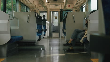 Front-end-of-a-moving-train-with-female-passenger-scrolling-on-her-phone