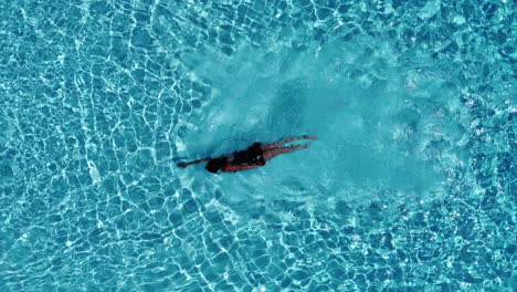 Vista-De-Pájaro-De-Una-Mujer-Nadando-En-La-Piscina---Disparo-De-Drone