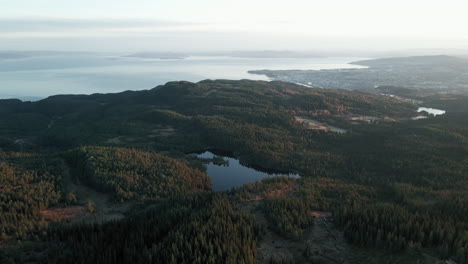 Bird's-Eye-View-Of-Forest-And-Baklidammen-Lake-With-Trondheim-City-And-Ocean-View-In-Norway