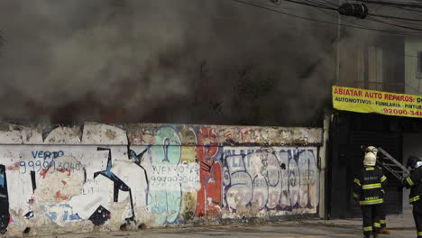 Un-Camión-De-Bomberos-Es-Guiado-Hacia-Un-Gran-Incendio-Urbano-Que-Arroja-Humo-Negro,-En-La-Avenida-Tereza-Cristina,-Distrito-De-Ipiranga