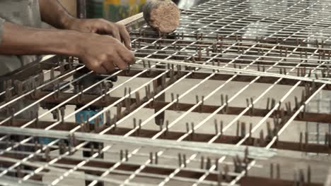 Male-Human-Hands-Placing-Mesh-Wire-Onto-Grid-Inside-Factory-In-Pakistan