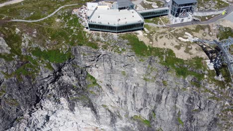 Spektakulärer-Aussichtspunkt-Am-Rande-Der-Hoven-Klippe---Loen-Skylift-Gebäude-Nähert-Sich-Der-Luftaufnahme-Mit-Nach-Unten-Gerichteter-Neigung---Draufsicht-Auf-Steile-Klippe-Und-Gebäude-Am-Rand---Norwegen