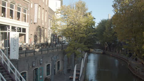 Tilting-up-from-restaurant-terrace-near-beautiful-canal-to-old-city-center-in-Utrecht,-the-Netherlands